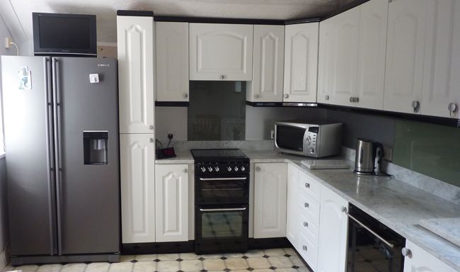 White kitchen design with silver fridge